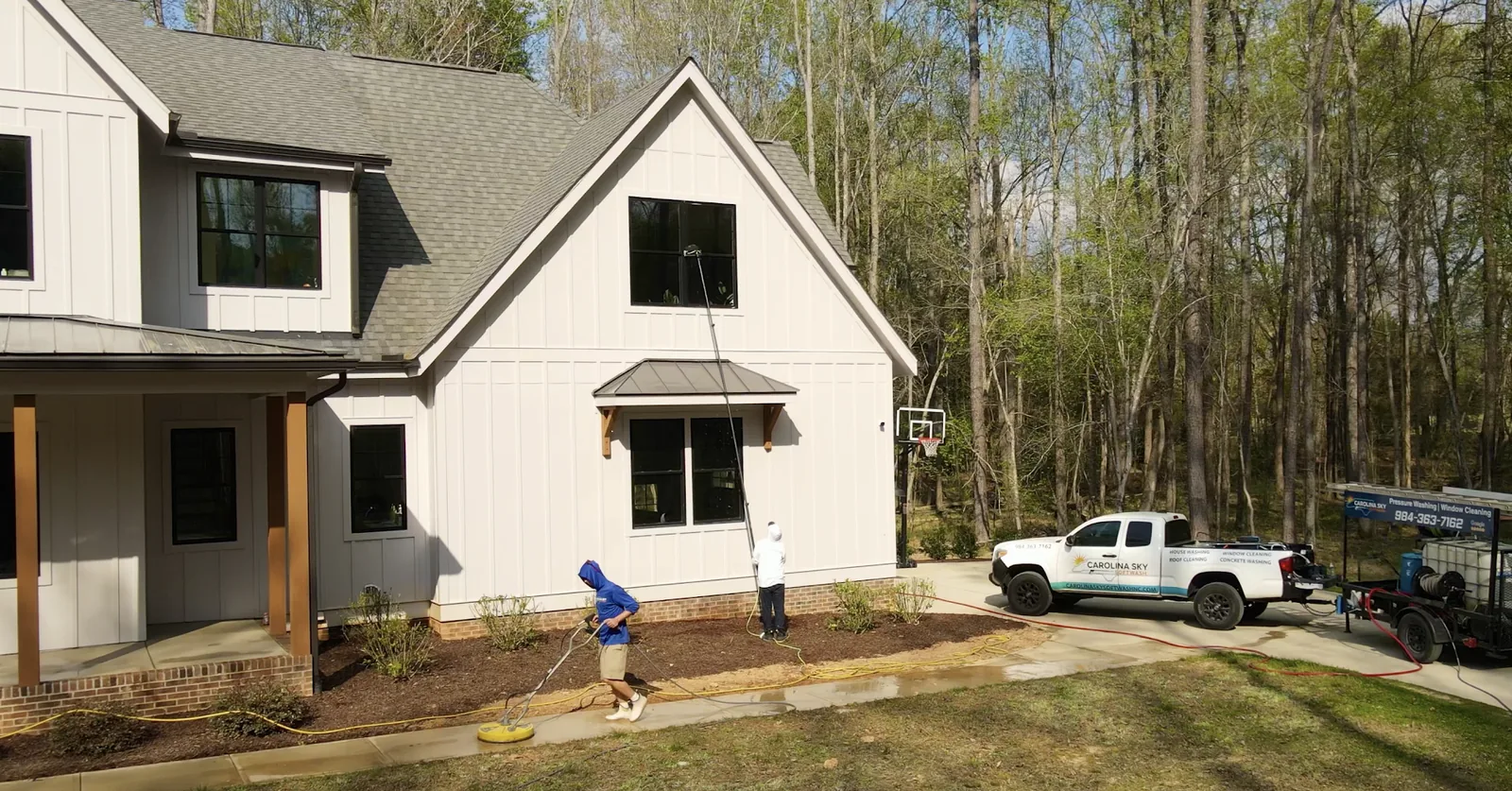Crew cleaning driveways and windows for community exterior maintenance