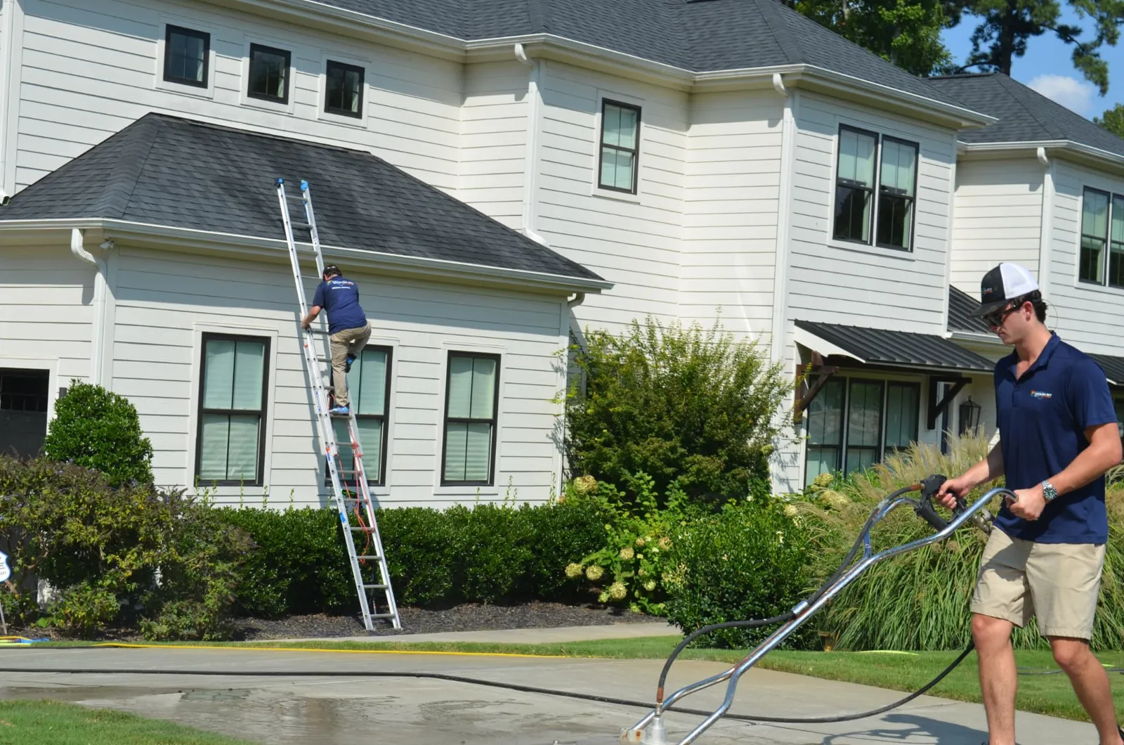 Roof and gutter line cleaning from a ladder at a North Carolina home