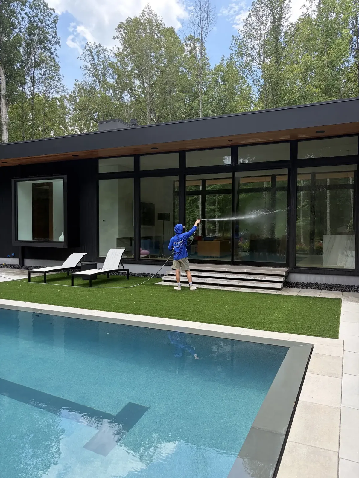 Window cleaning on a modern home beside a pool in the Triangle, NC